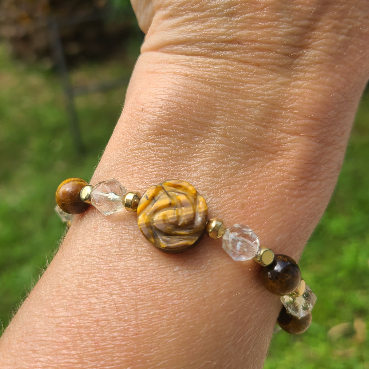 Bracelet porté sur un bras en citrine et oeil de tigre