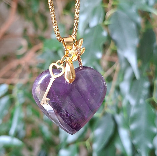 Collier coeur en améthyste sur fond de verdure avec breloques clé et fée