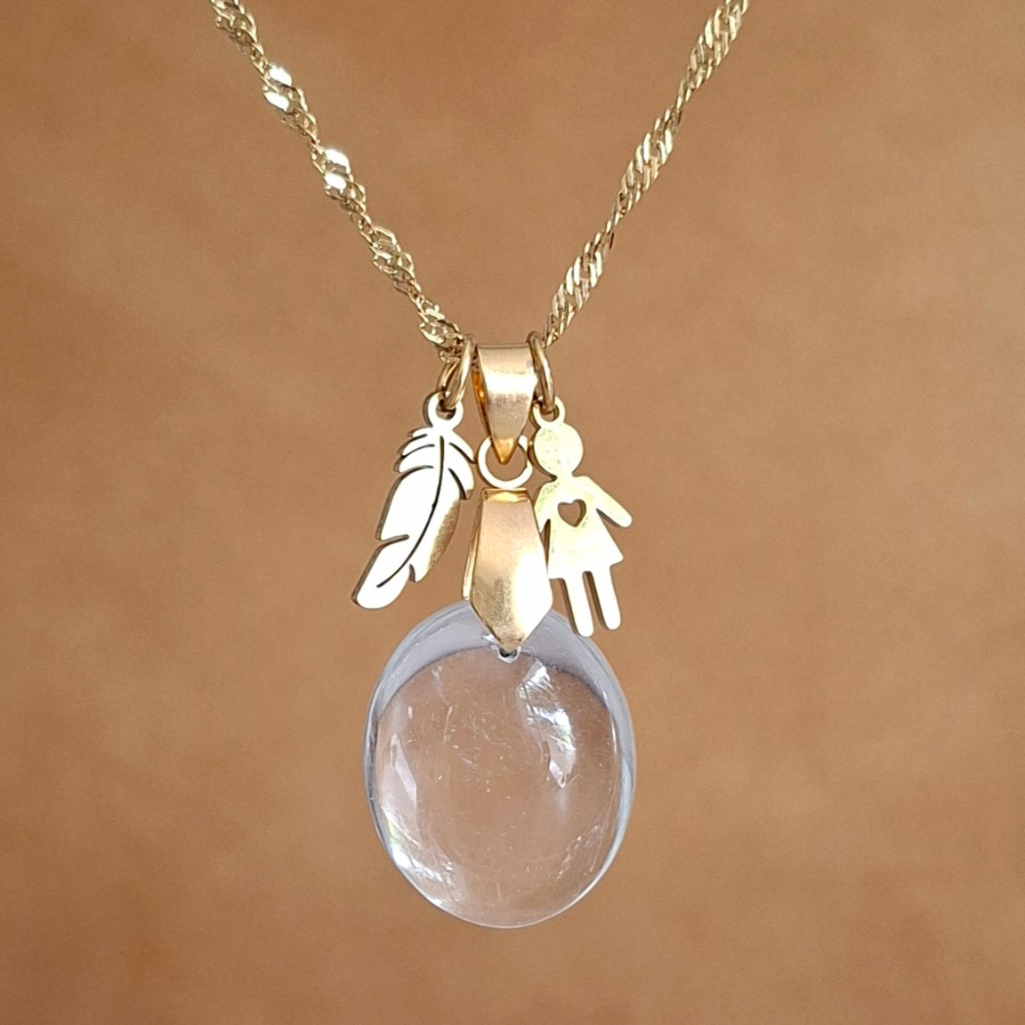 Collier en cristal de roche naturel, pierre ovale sur chaîne dorée.