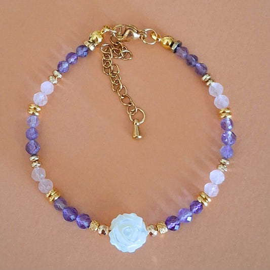Bracelet Célia en perles facettées d'améthyste et de quartz rose, avec rose centrale en nacre et finitions dorées