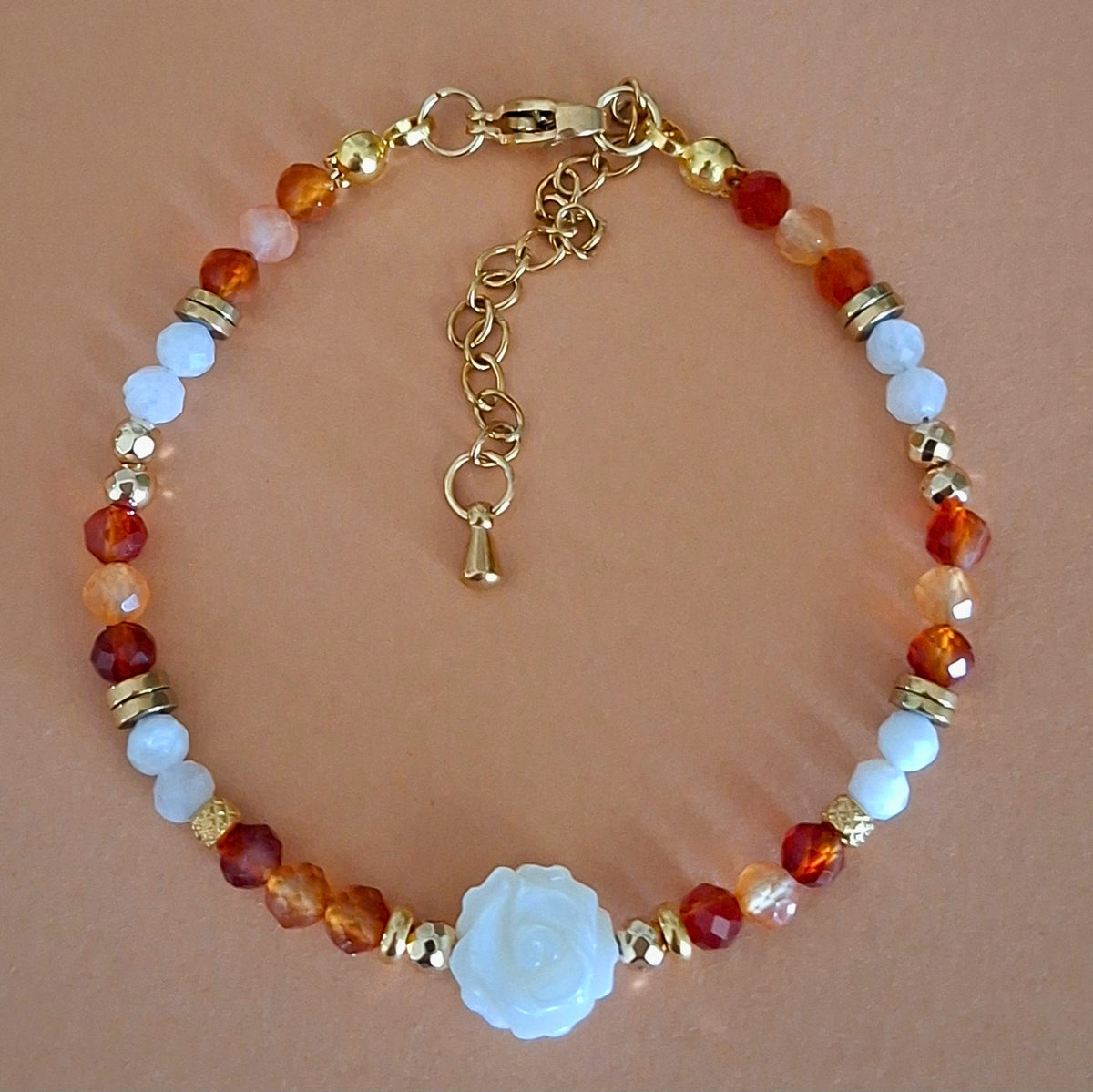 Bracelet Célia en perles facettées de cornaline et pierre de lune arc-en-ciel, avec rose centrale en nacre et finitions dorées