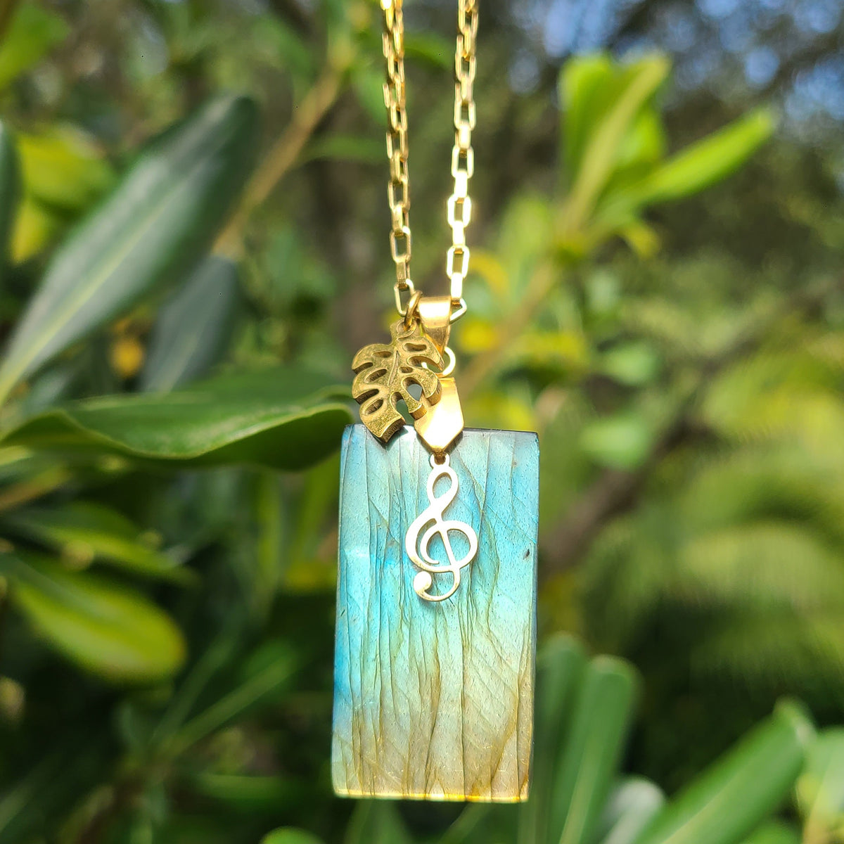 Collier acier doré en labradorite rectangulaire avec breloques feuille et clé de sol. Petite Rainette Bijoux