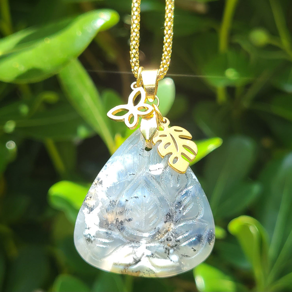 Collier acier doré en opale dendrite triangulaire ciselée avec breloques papillon et feuille
