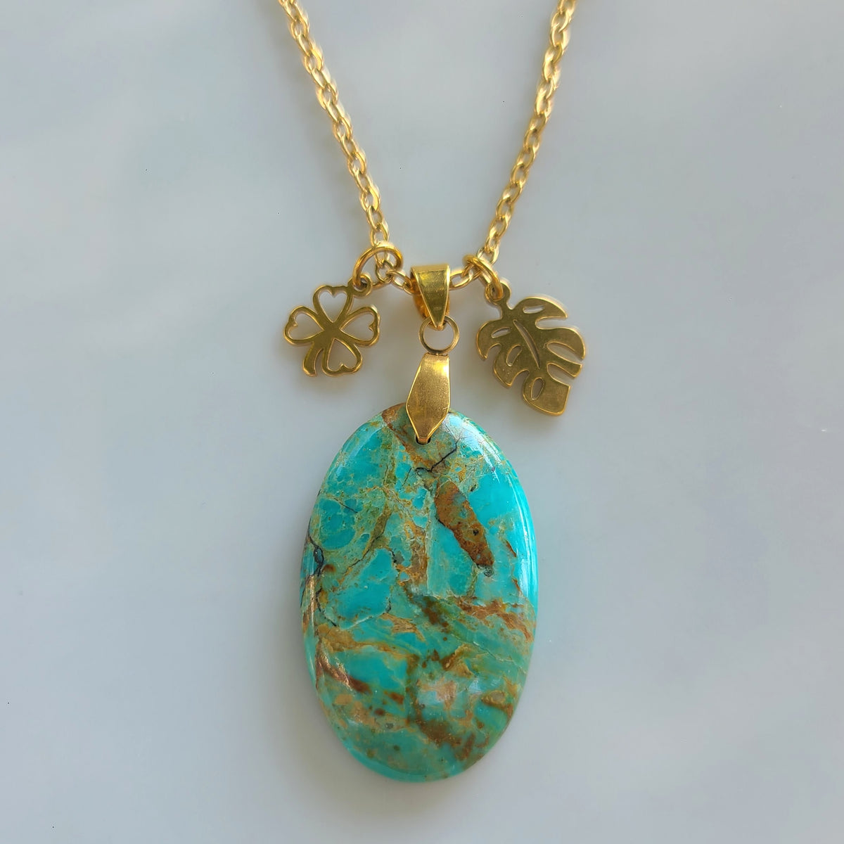 Collier en acier et turquoise Mohave ovale avec breloques dorées feuille et trèfle
