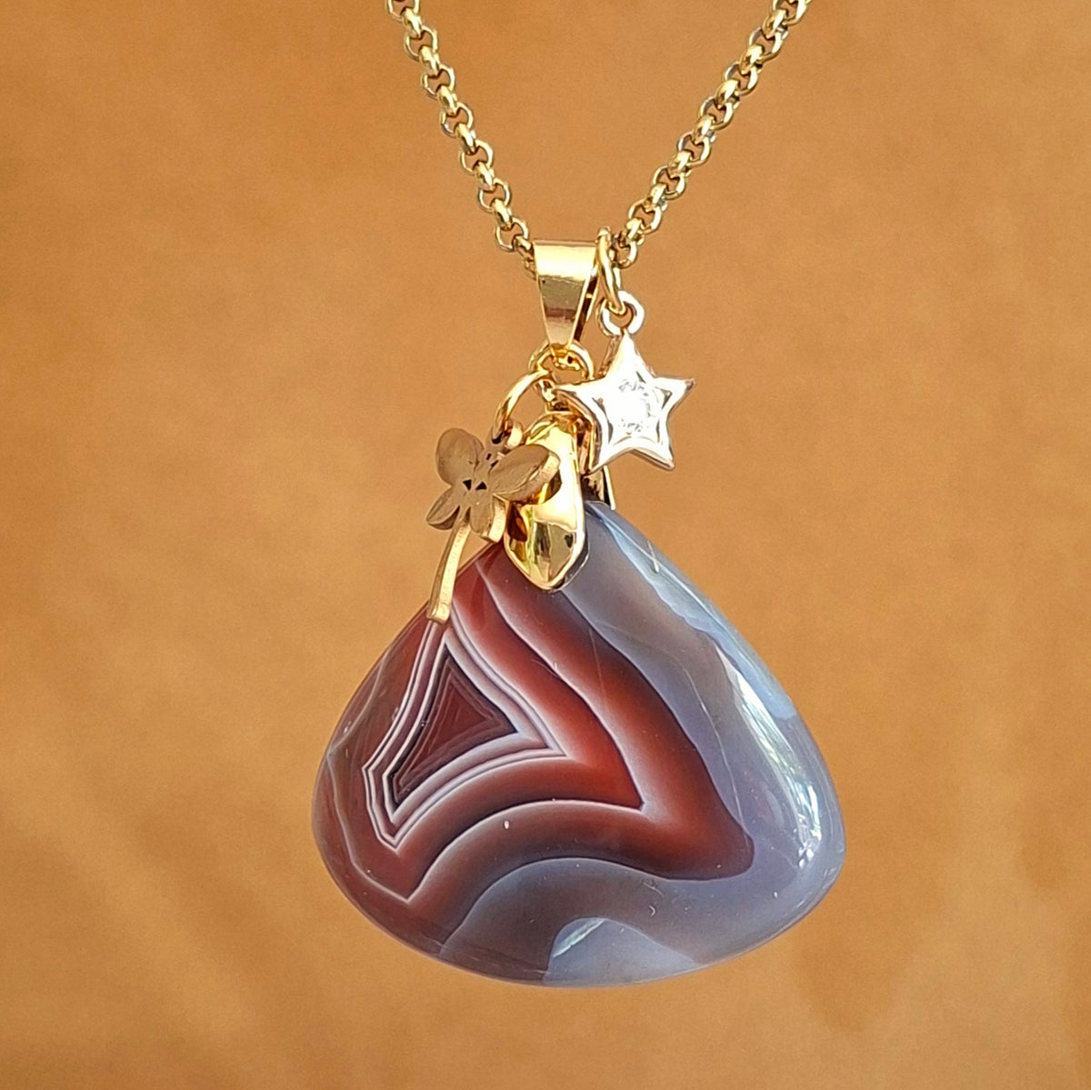 Collier en agate du Botswana triangulaire sur chaîne dorée acier et breloques papillon et étoile