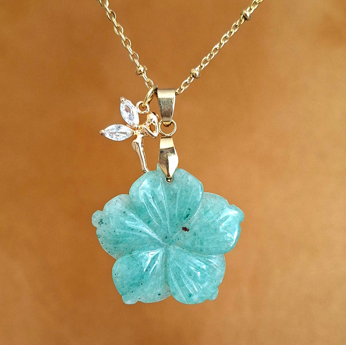 Collier en acier doré avec une aventurine taillée en forme de fleur et une breloque fée