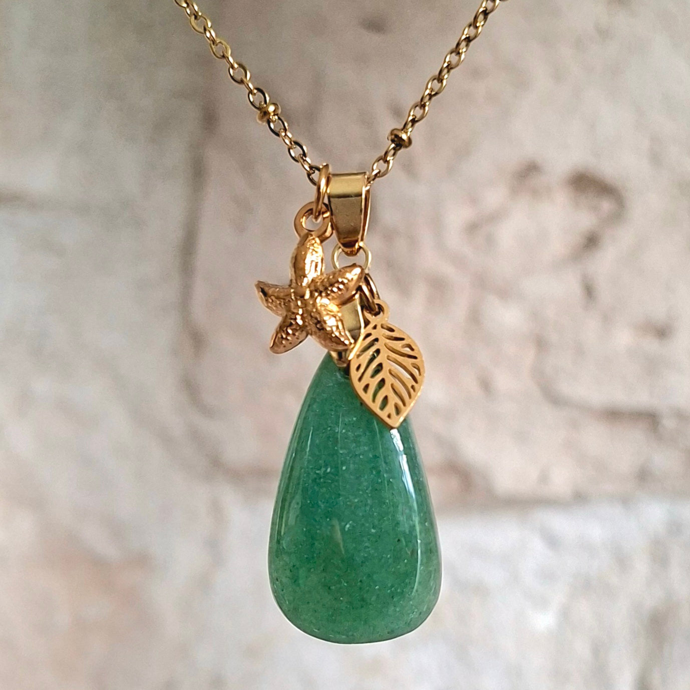 Collier en aventurine poire sur chaîne dorée maille perlée avec breloques étoile de mer et feuille.