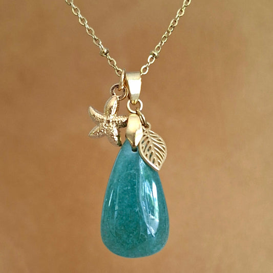 Collier en aventurine poire sur chaîne dorée maille perlée avec breloques étoile de mer et feuille.