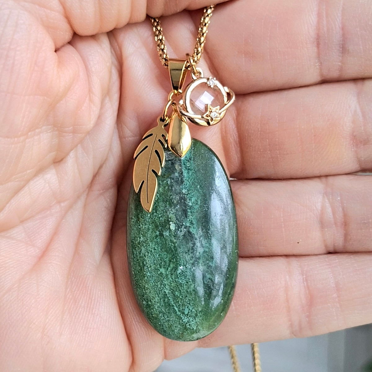 Collier aventurine longue ovale naturelle chaine acier dor et breloques plume et étoile dans la main