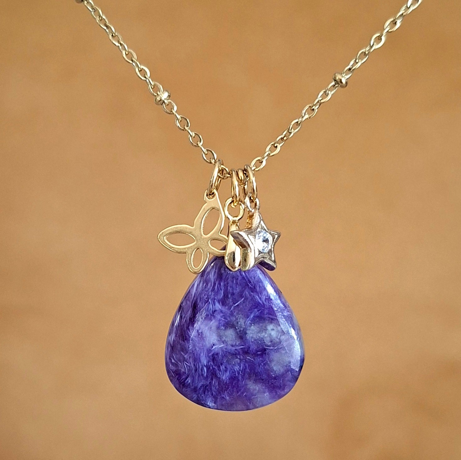 Collier en charoïte naturelle violette forme goutte avec breloques papillon et étoile zirconium.