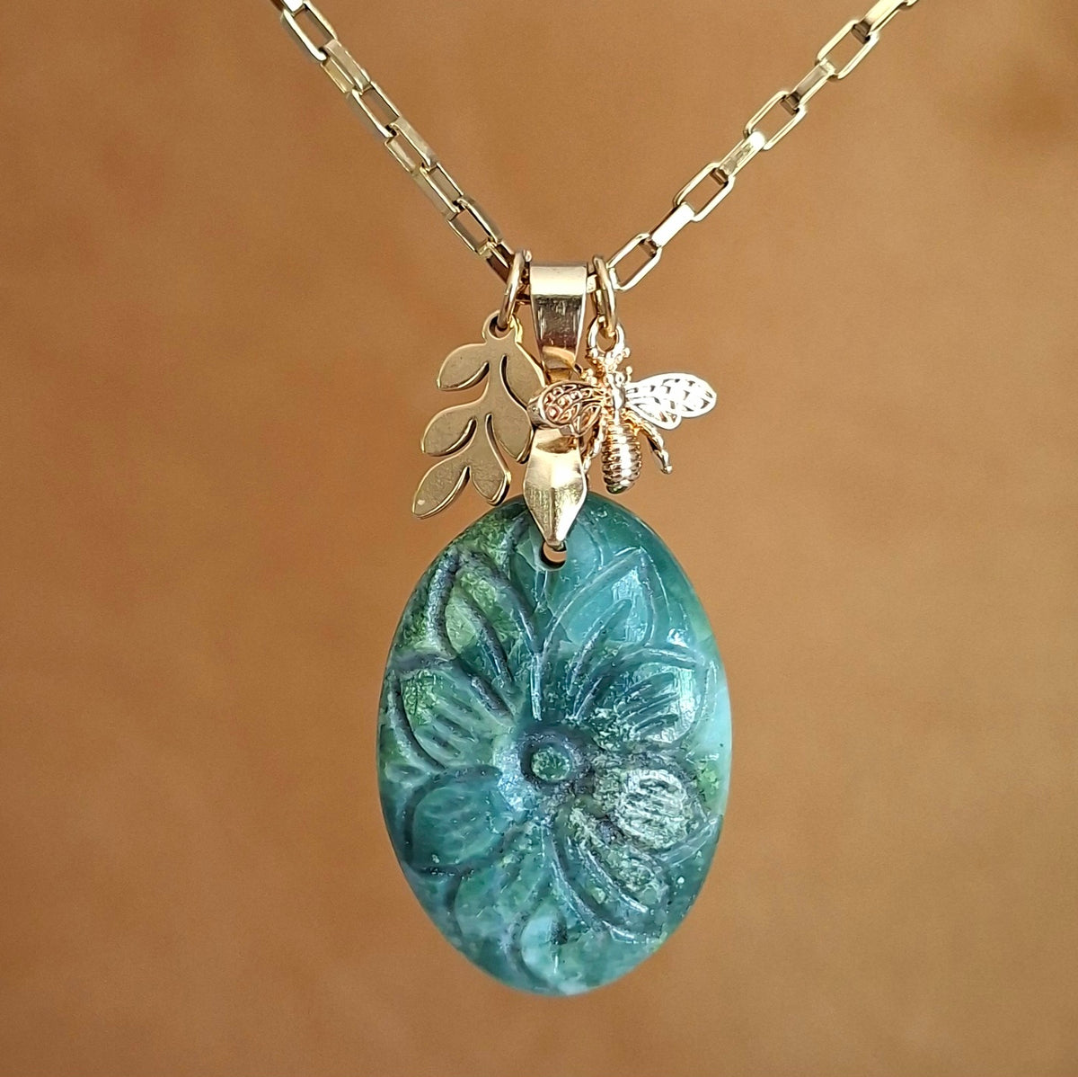 Collier en chrysoprase naturelle ovale ciselée, sur chaîne en acier inoxydable doré avec breloques