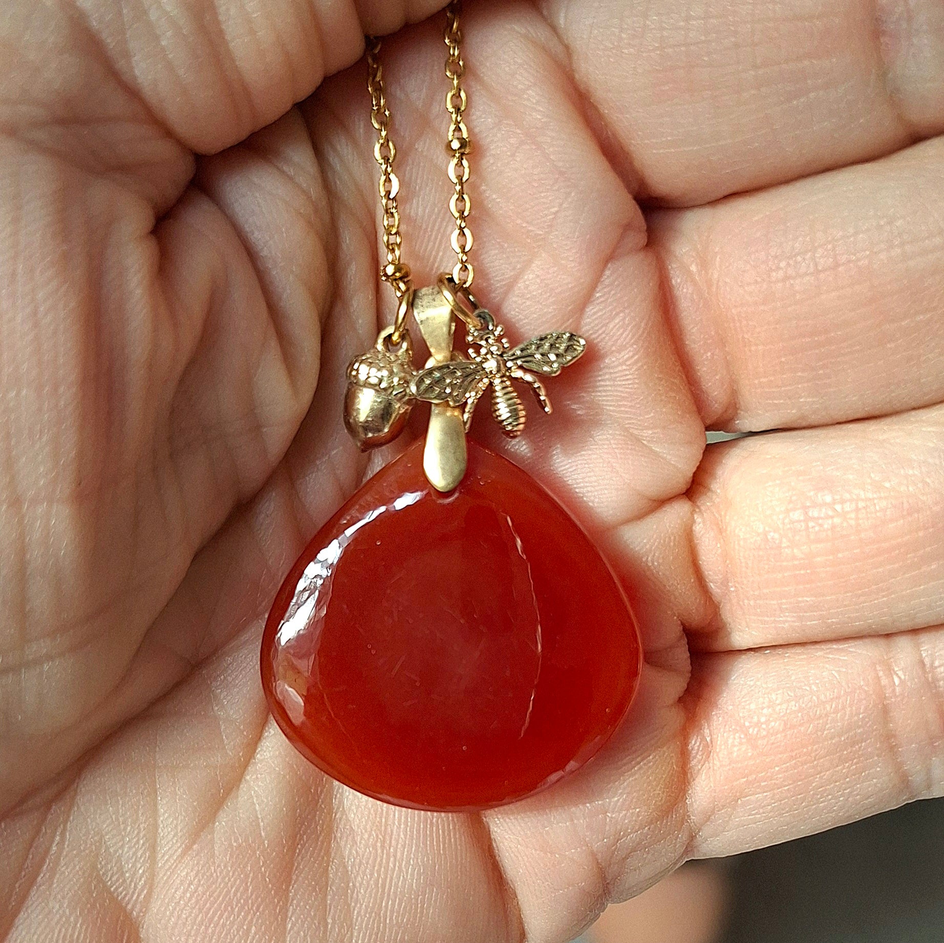 Collier cornaline forme goutte en acier inoxydable doré vue dans la main - petite Rainette