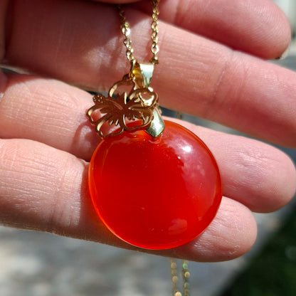 Collier en cornaline ronde sur chaine acier doré dans la main