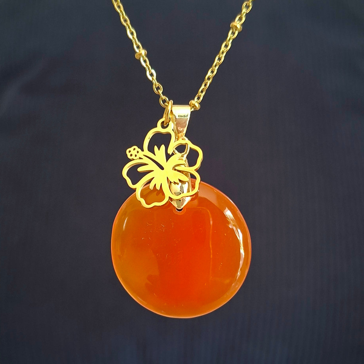 Collier en cornaline ronde sur chaine acier doré avec breloque fleur d'hibiscus