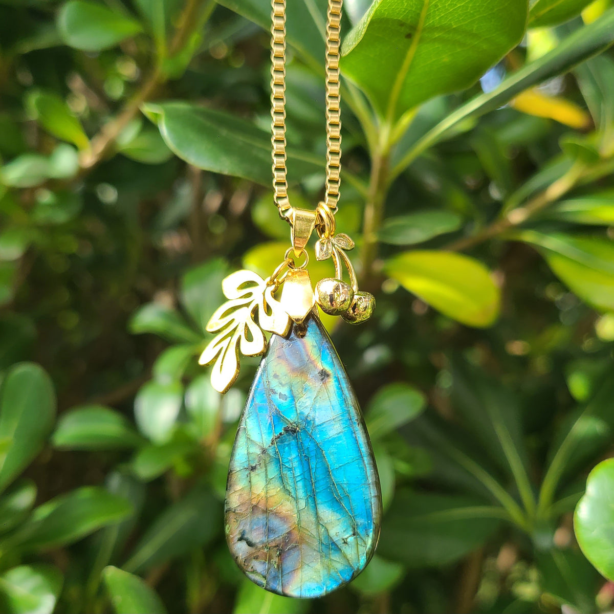 Collier en labradorite en forme de poire avec breloques feuille et cerises en acier doré. Petite Rainette Bijoux