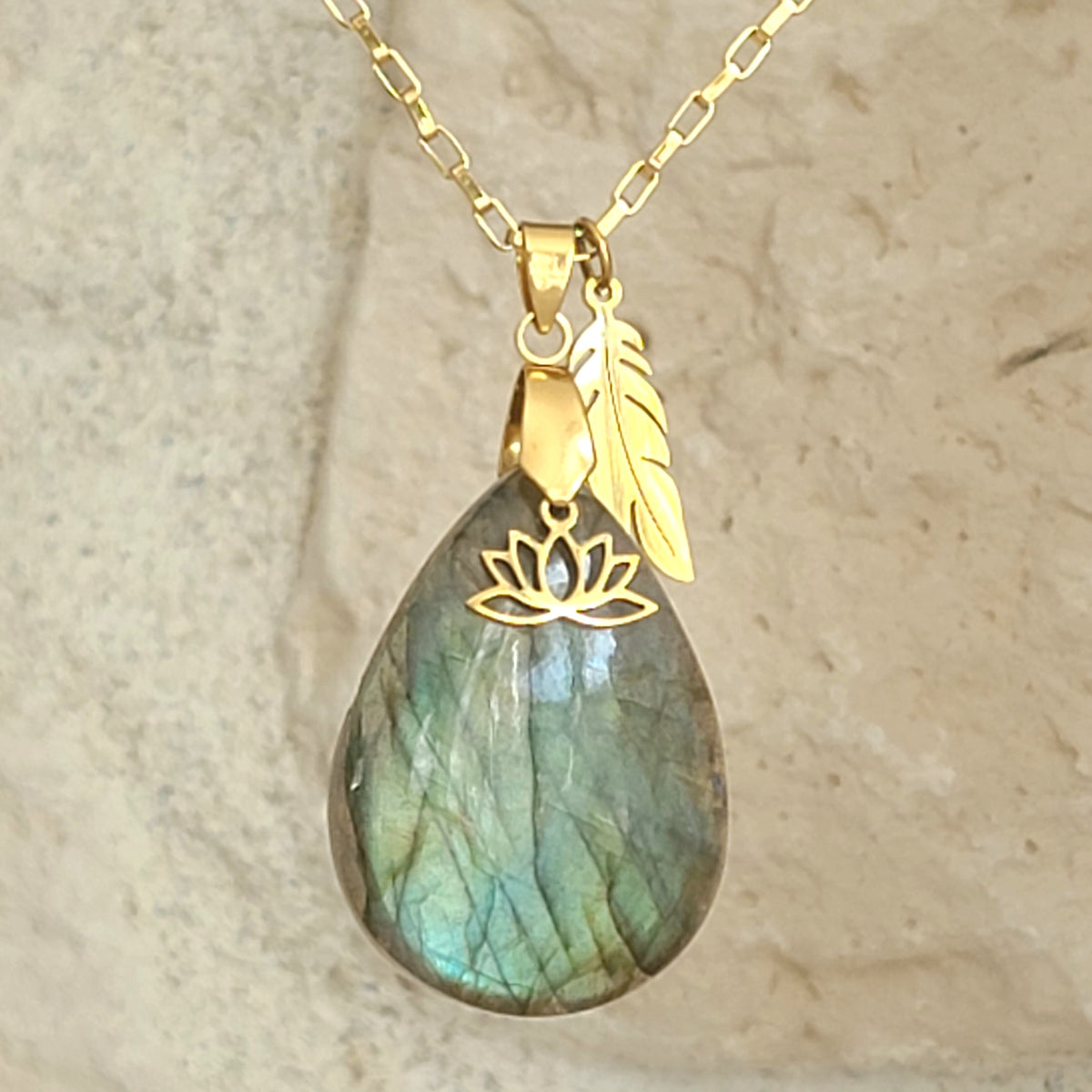 Collier en labradorite en forme de poire (goutte)  avec breloques plume et fleur de lotus en acier doré. Petite Rainette Bijoux
