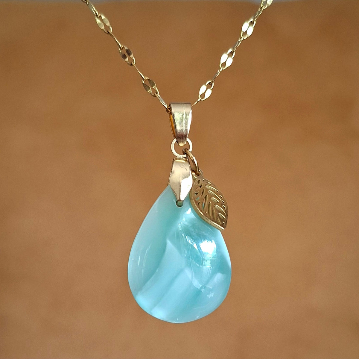 Collier en hémimorphite verte sur chaîne en acier doré avec breloque feuille. 