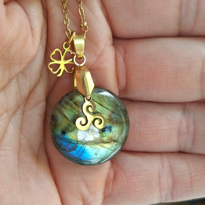 Collier en labradorite naturelle ronde présenté dans la main, chaîne maille perlée en acier inoxydable doré.