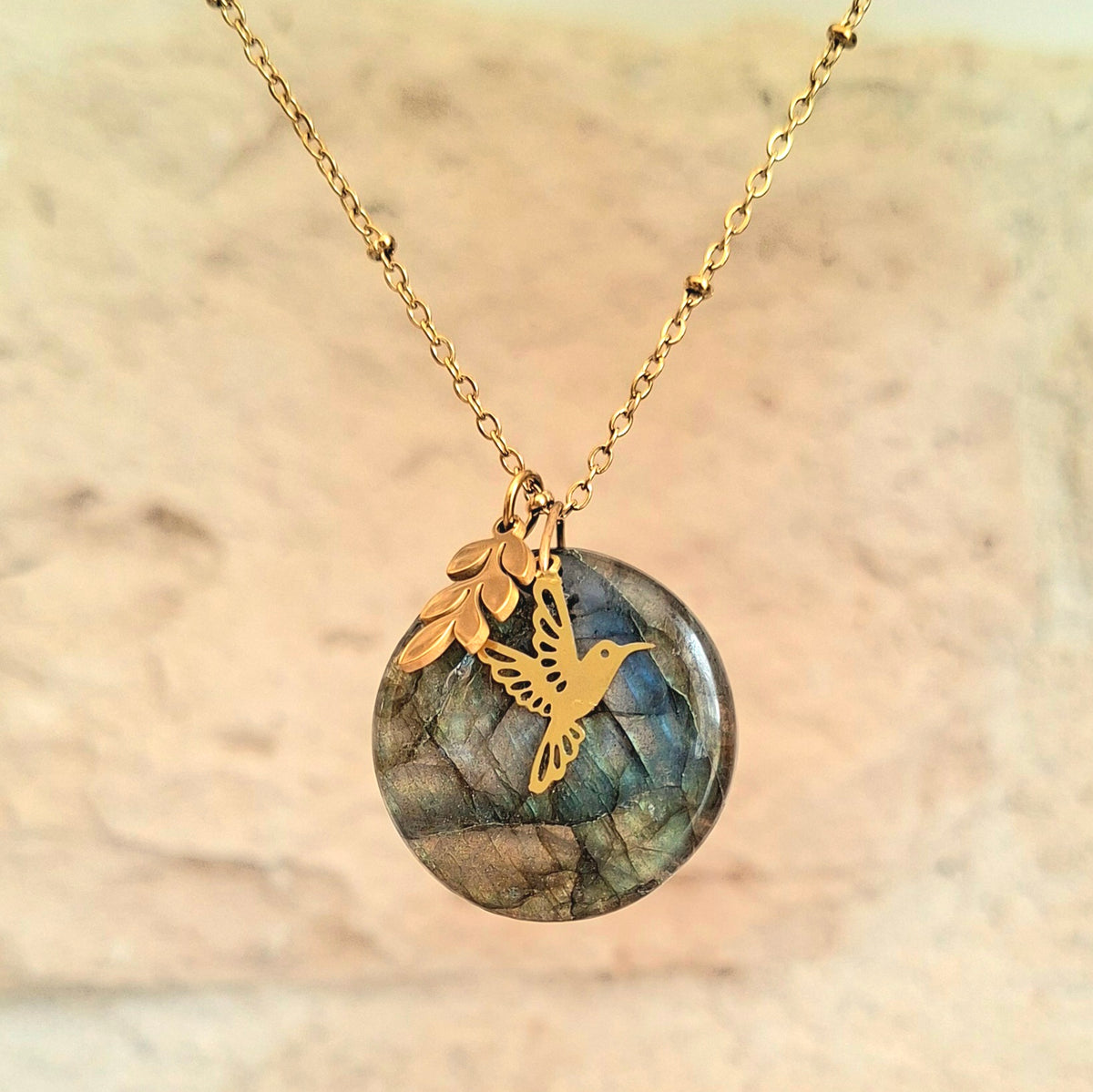 Collier en labradorite ronde avec breloques feuille et colibri en acier inoxydable doré. Petite Rainette Bijoux