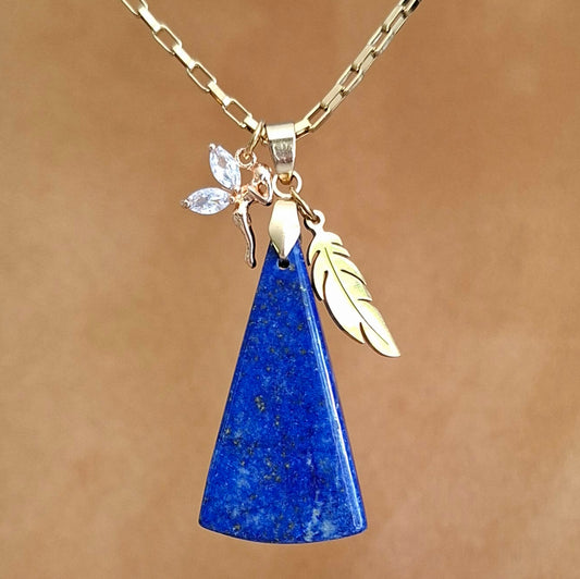 Collier en lapis-lazuli triangulaire bleu profond avec breloques plume et fée dorées.