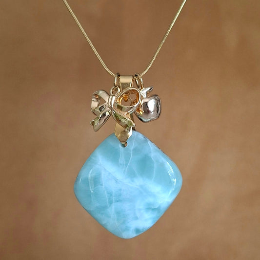 Collier en larimar carré avec breloques nœud et pomme en laiton doré à l'or fin.