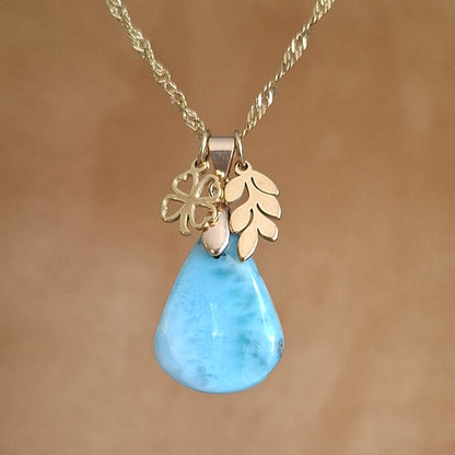 Collier en acier inoxydable doré avec larimar bleu taillé en poire, breloques feuille et trèfle.