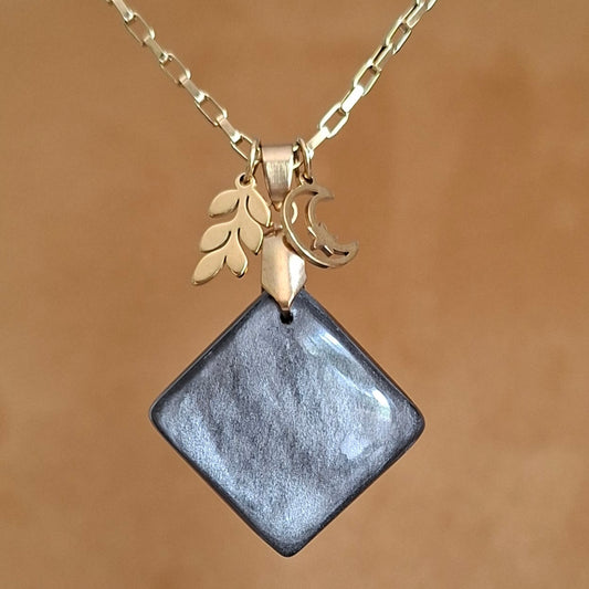 Collier en acier doré et obsidienne argentée avec breloques lune et feuille