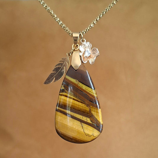 Collier acier doré et oeil de tigre forme poire avec breloques plume et fleur