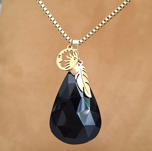 Collier en onyx noir à facettes sur chaîne dorée avec breloques plume et soleil