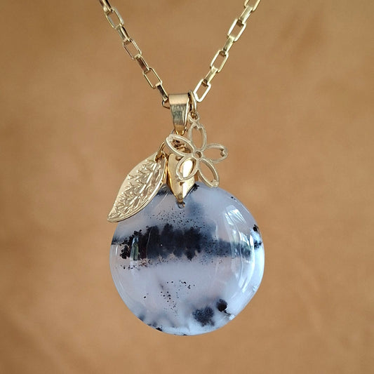 Collier en opale dendrite ronde sur chaîne dorée avec breloques fleur et feuille