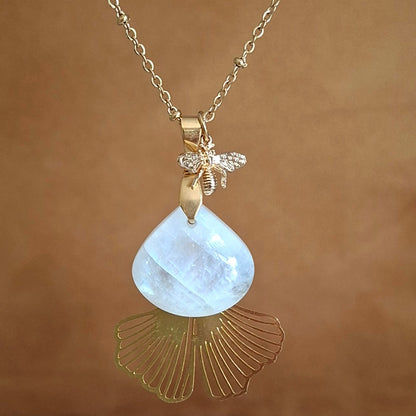 Collier acier doré et pierre de lune triangulaire avec beloques abeille et ginkgo