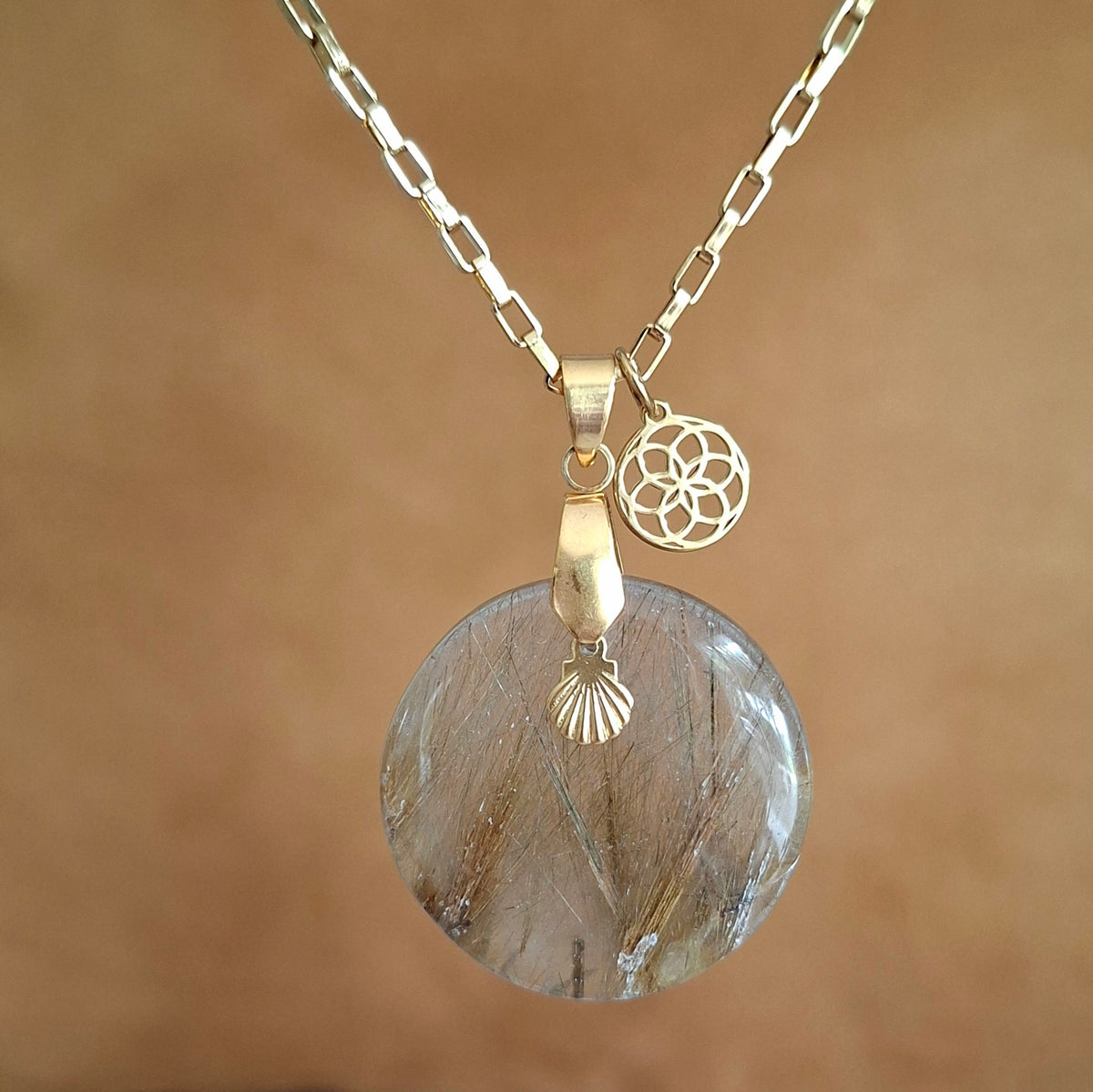 Collier en quart rutile rond sur chaine acier doré avec breloques dorées