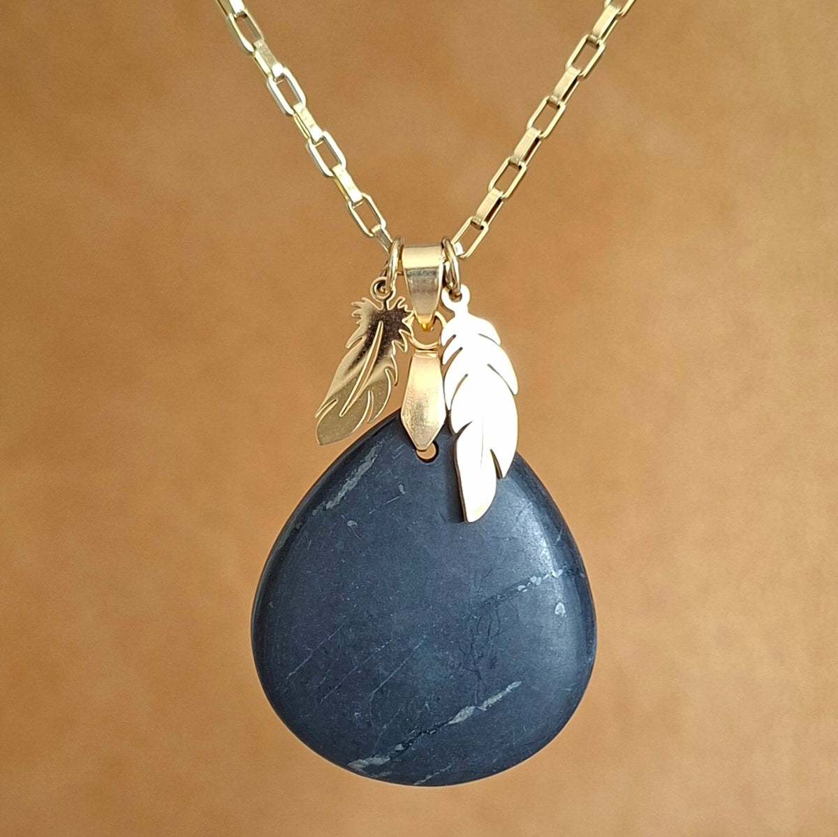 Collier en shungite naturelle taillée en forme de poire, sur chaîne dorée avec breloques plumes