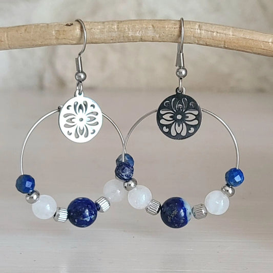 Boucles d’oreilles créoles en acier inoxydable argenté avec perles de lapis-lazuli, quartz laiteux et médaillon ajouré.