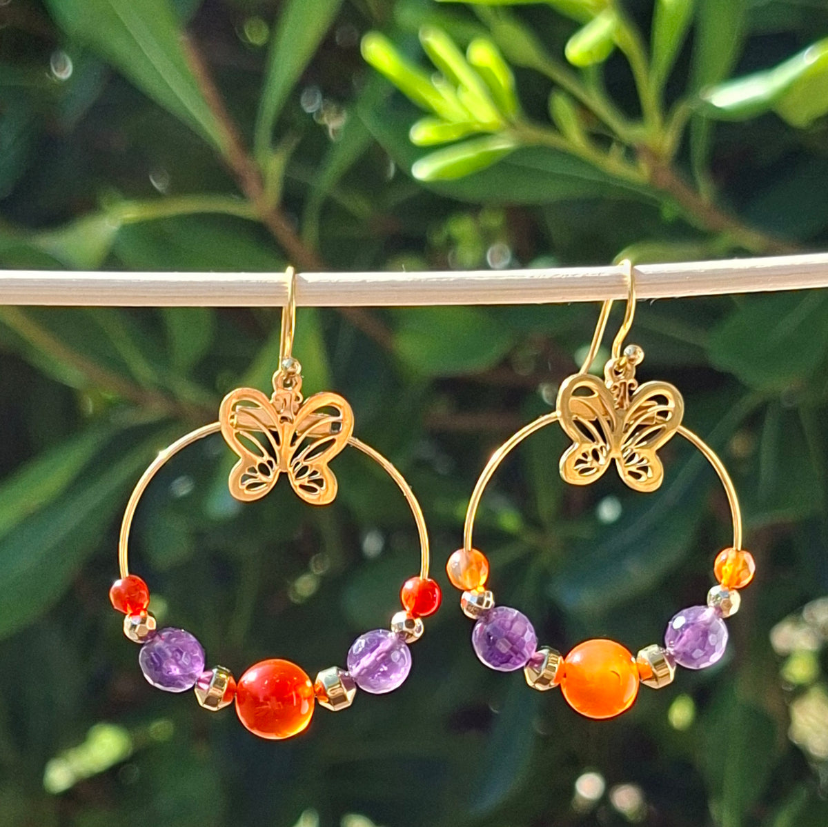 Boucles d'oreilles créoles dorées en cornaline et améthyste avec breloque papillon