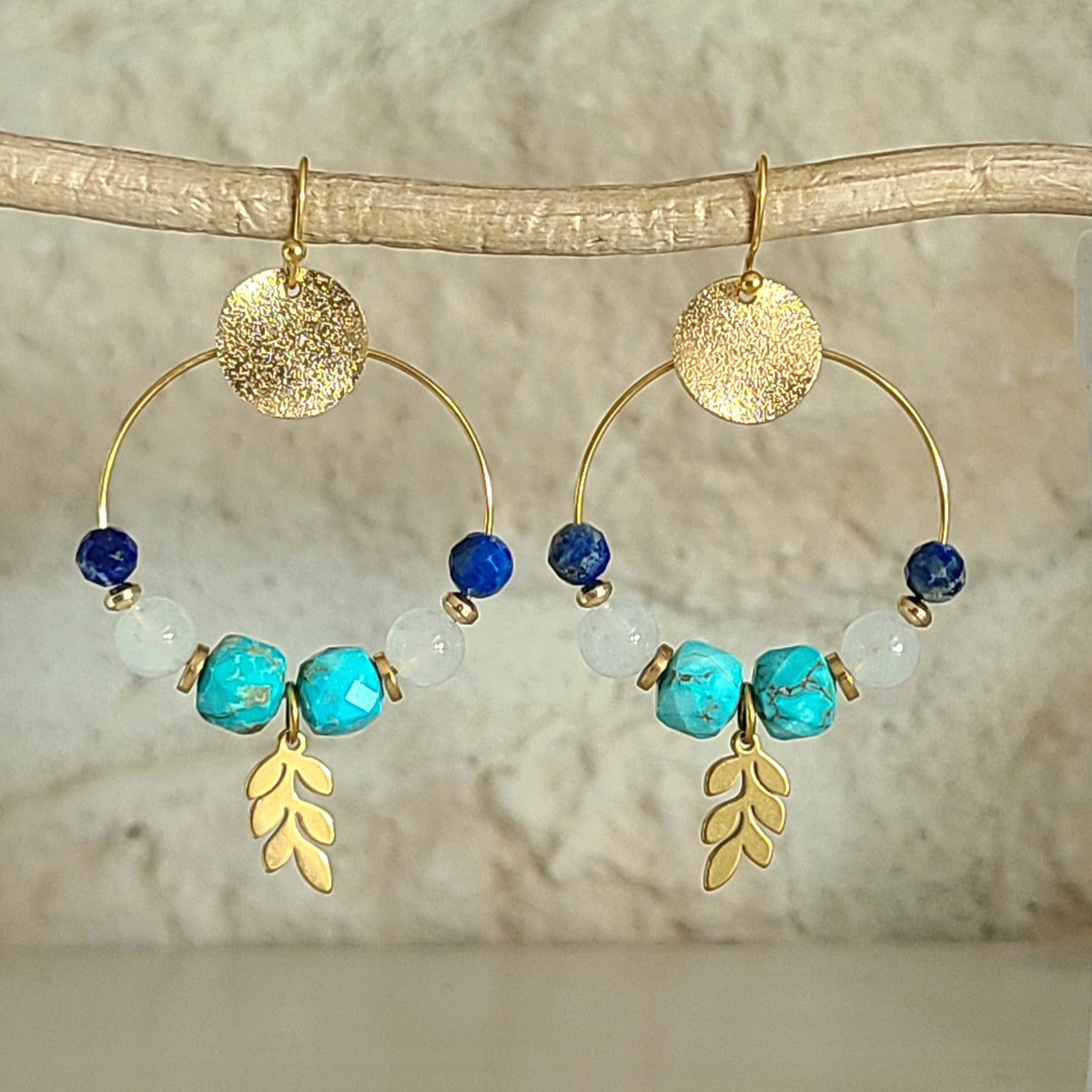 Boucles d’oreilles créoles dorées avec pierres naturelles turquoise, lapis-lazuli, quartz laiteux et médaillon en acier brossé.