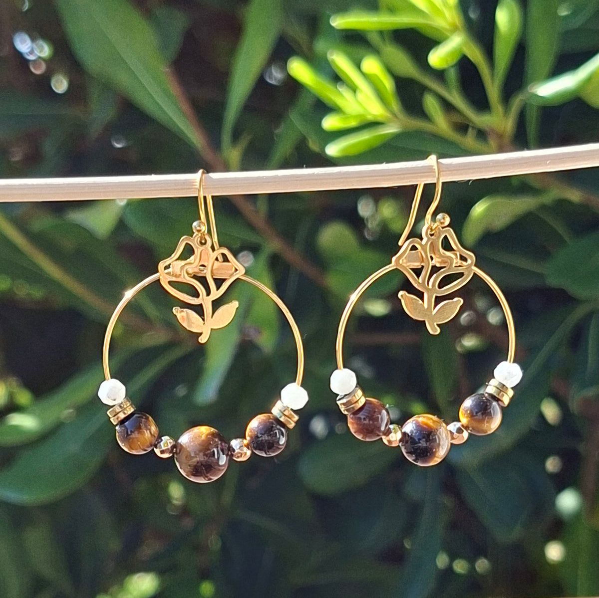 Boucles d'oreilles créoles en acier et oeil de tigre avec breloque rose