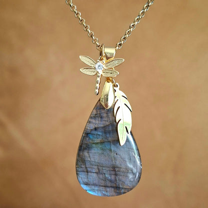 Collier en labradorite naturelle goutte aux reflets bleus et dorés avec plume et libellule dorées.