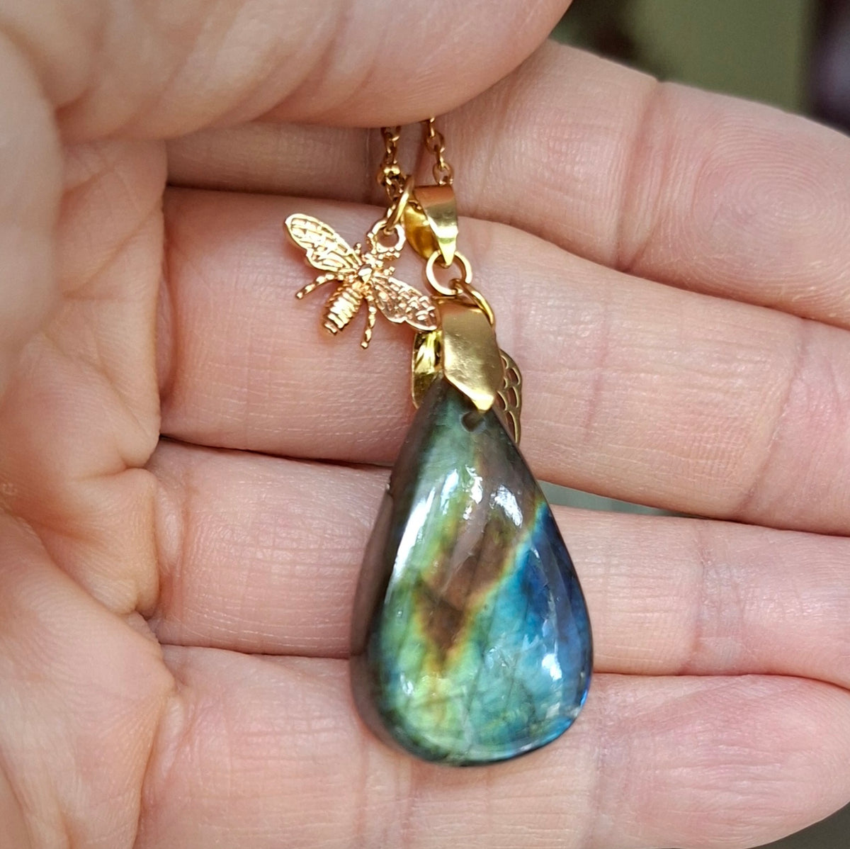 Labradorite forme goutte muticolore dans la main