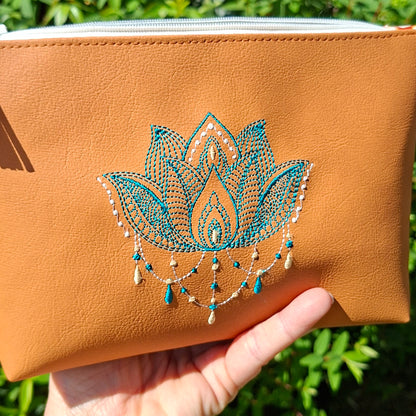 Trousse femme brodée lotus en simili cuir camel tenue en main