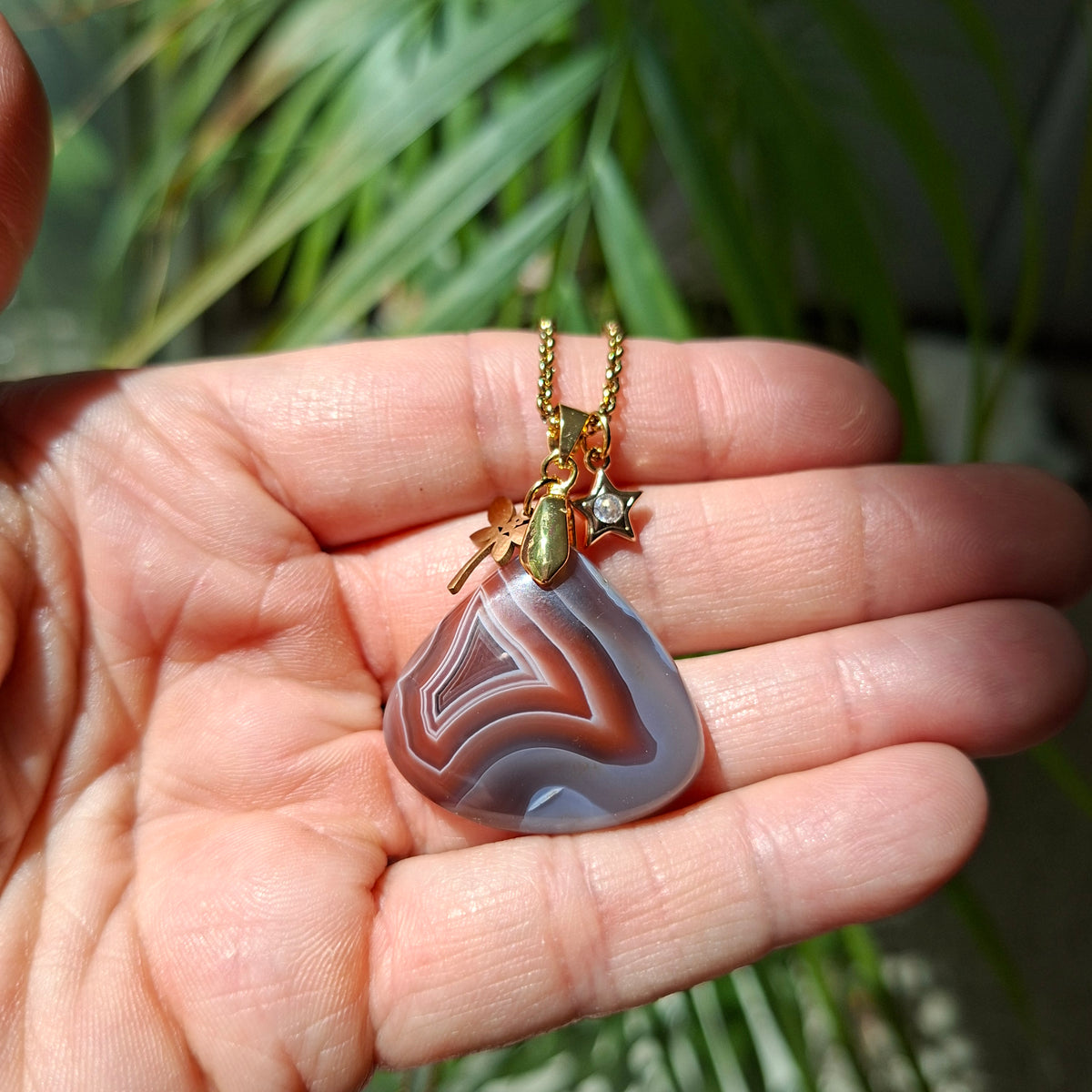Collier agate du Botswana et chaîne acier doré dans la main