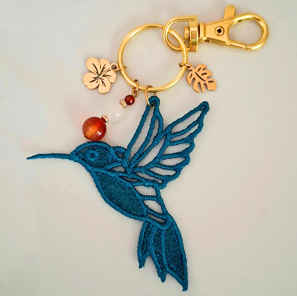 Bijou de sac Colibri artisanal avec pierres naturelles et détails dorés