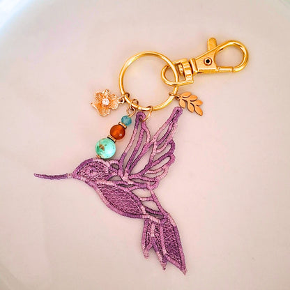 Bijou de sac Colibri Joie de vivre mauve brodé avec turquoise d’Afrique, cornaline et apatite