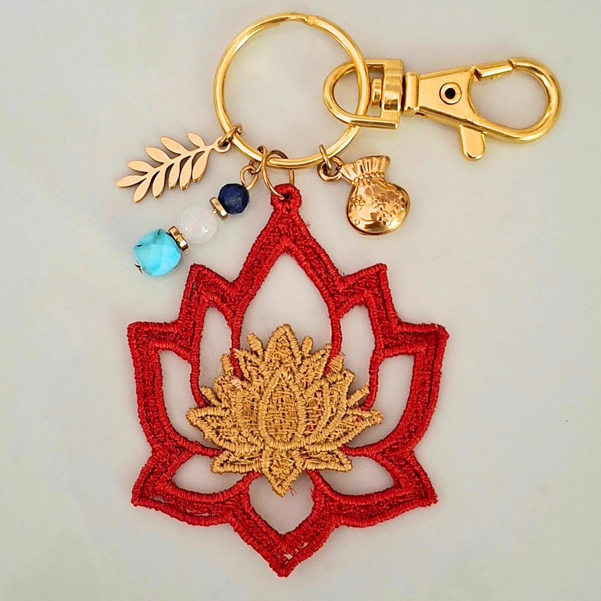Bijou de sac Lotus artisanal avec pierres naturelles et détails dorés