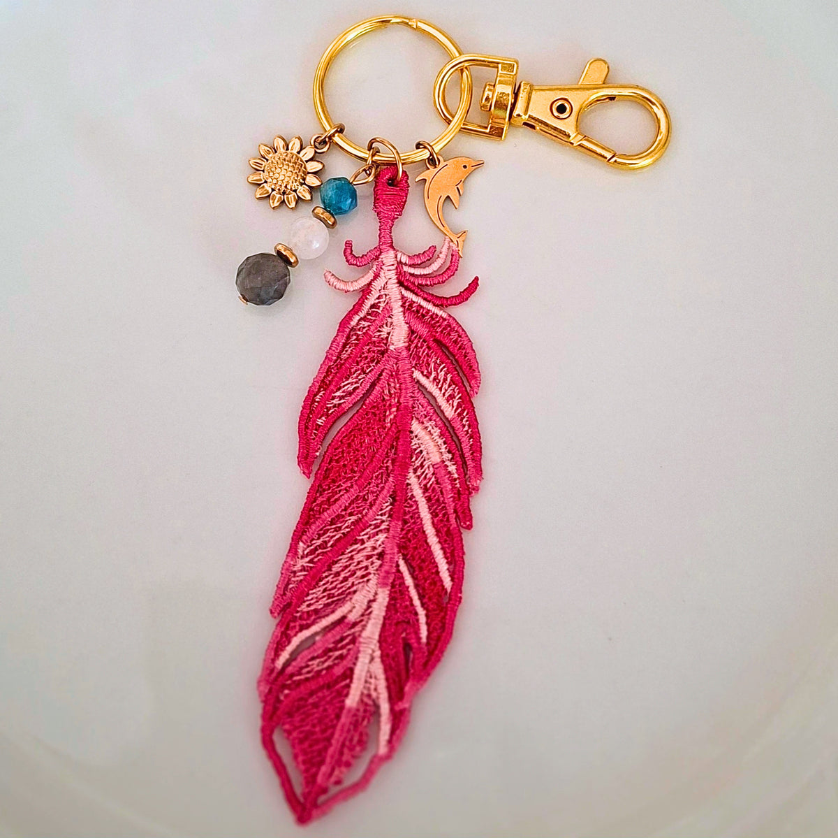 Bijou de sac Plume Liberté fuchsia brodée avec labradorite, pierre de lune et apatite