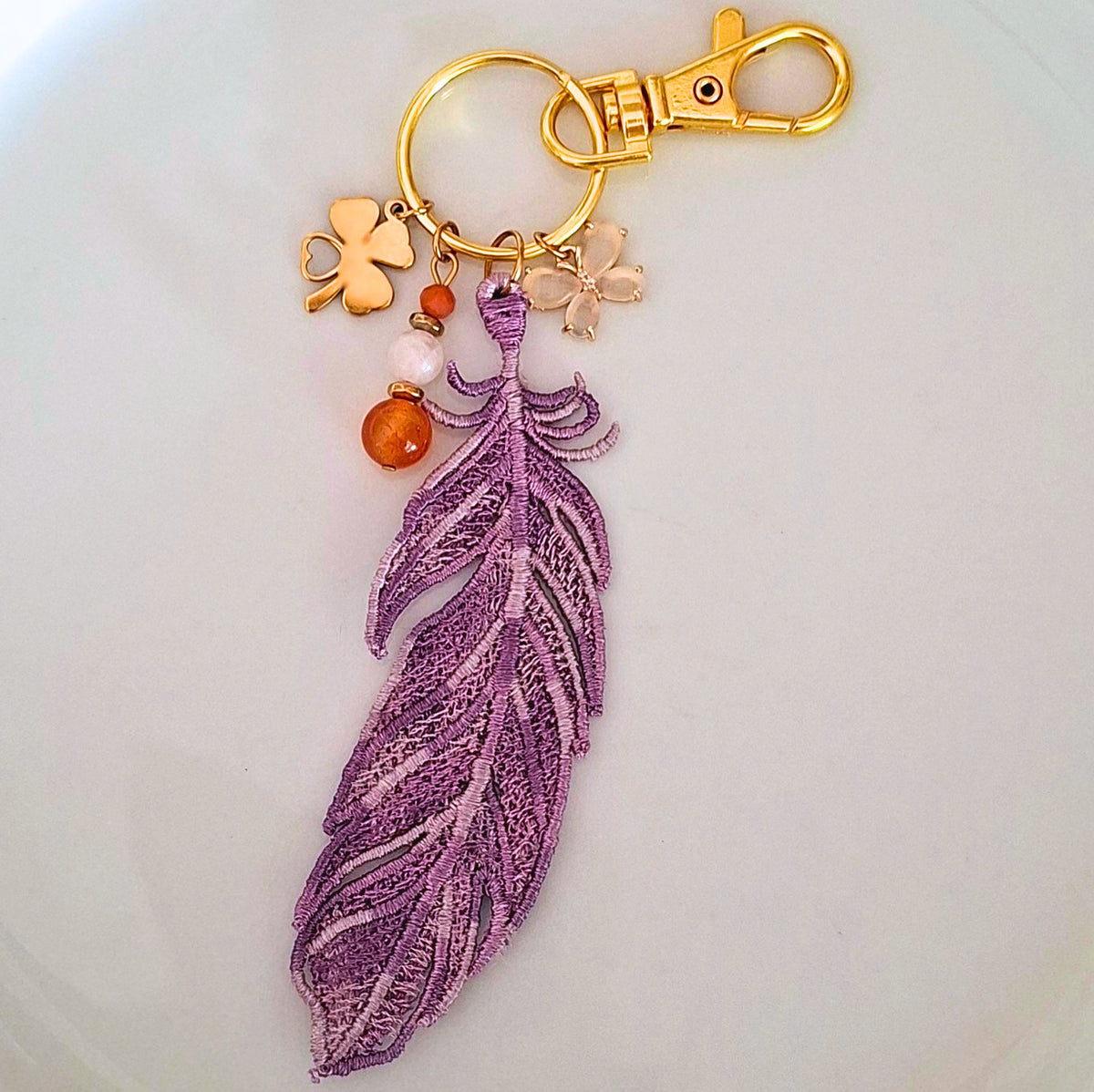 Bijou de sac Plume Liberté mauve brodée avec cornaline et quartz rose