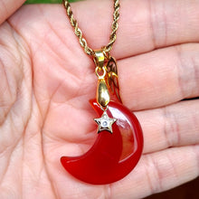 Charger l'image dans la galerie, Collier lune en cornaline orange présenté dans la main avec breloques aile et étoile.