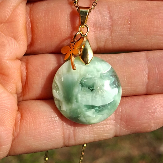 Collier artisanal en hémimorphite naturelle dans la main avec chaîne dorée et breloque libellule