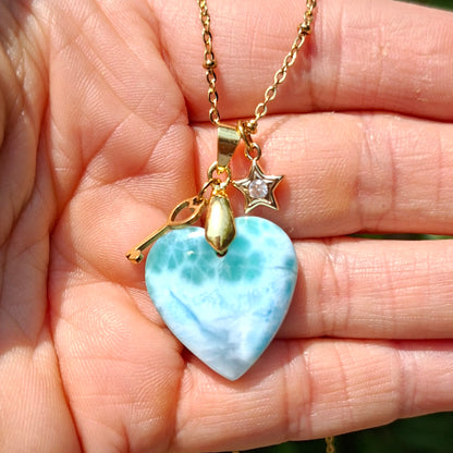 Collier en larimar cœur présenté dans la main avec breloques dorées