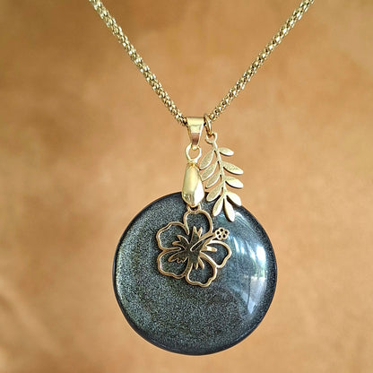 Collier en obsidienne dorée ronde naturelle avec fleur d'hibiscus et feuille dorées.